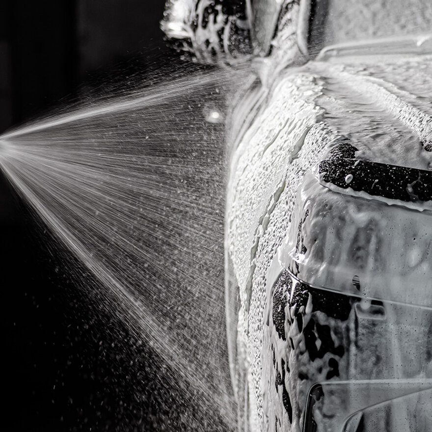 A car during a car wash getting cleaned with car shampoos from the car wash alliance