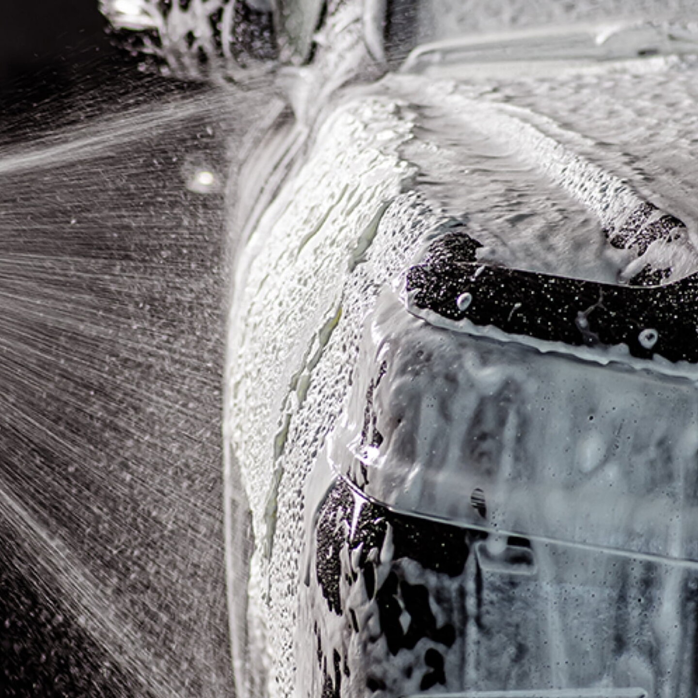 Close-up of foaming car wash shampoo on a car 